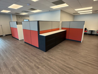 modern office with wood floors and red and grey cubicles