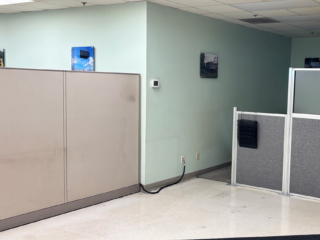 outdated office with light colored walls and cubicles