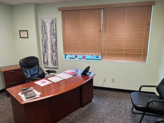 dark office with large desks and black chairs