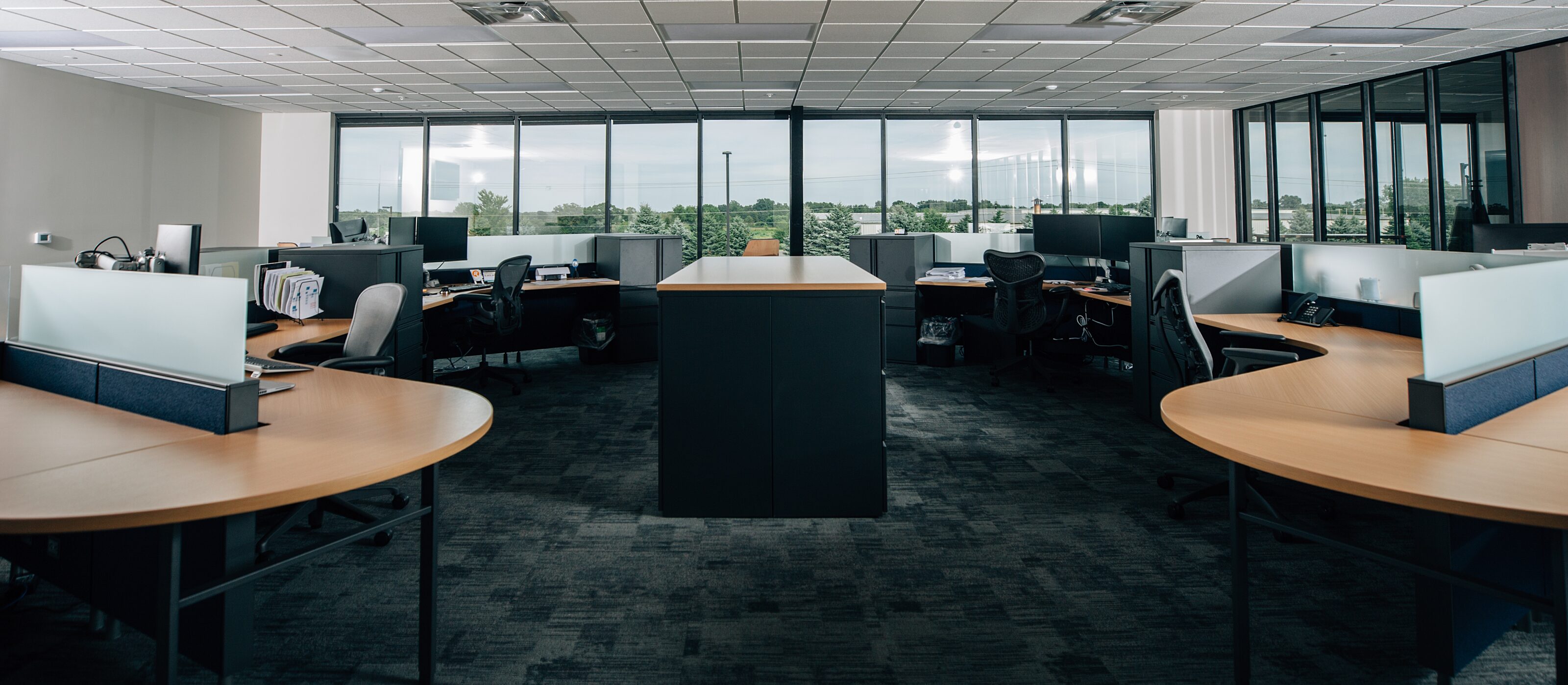 open office space with large windows and light wood desktops